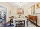 Formal dining room with hardwood floors, elegant chandelier, and colorful abstract painting at 411 Circle Dr, Burlington, NC 27215