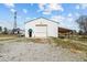 Side view of a white metal barn with covered parking and an RV trailer beside it at 4194 Abattoir Rd, Angier, NC 27501