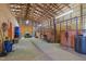 Spacious barn interior featuring horse stalls and ample room for equipment storage with a tractor inside at 4194 Abattoir Rd, Angier, NC 27501