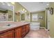 Well-lit bathroom with double sinks, soaking tub, and walk-in shower at 4194 Abattoir Rd, Angier, NC 27501