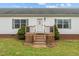 Close-up of a home's entrance with a small wooden porch and meticulously maintained landscaping at 4194 Abattoir Rd, Angier, NC 27501