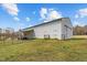 Side view of outbuilding with split rail fence, walk-in doors, and connected carport on a lush, green lawn at 4194 Abattoir Rd, Angier, NC 27501