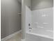 Bathroom featuring a white tiled shower and neutral tiling, with updated faucet at 556 Village Loop Dr, Apex, NC 27502
