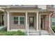 Inviting covered front porch of a townhome with brick pillars and decorative front door at 556 Village Loop Dr, Apex, NC 27502