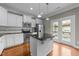 Eat-in kitchen features stainless steel appliances, granite countertops, kitchen island, and access to outdoor deck at 556 Village Loop Dr, Apex, NC 27502
