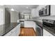 Bright kitchen features stainless steel appliances, granite countertops, white cabinets and wood flooring at 556 Village Loop Dr, Apex, NC 27502
