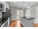 Eat-in kitchen with stainless steel appliances, island with granite countertops, and access to the outdoor deck at 556 Village Loop Dr, Apex, NC 27502