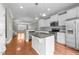 Open concept kitchen with a center island, stainless appliances, and wood flooring at 556 Village Loop Dr, Apex, NC 27502