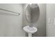 Clean powder room featuring a pedestal sink, oval mirror and modern fixtures is located on the first floor at 556 Village Loop Dr, Apex, NC 27502
