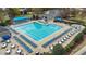 An aerial view of an outdoor community swimming pool with a sundeck filled with tables and lounge chairs at 556 Village Loop Dr, Apex, NC 27502