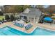 An aerial view of a community pool with lounge chairs and a clubhouse with covered patio at 556 Village Loop Dr, Apex, NC 27502