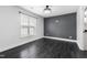 Modern bedroom featuring a dark accent wall, large window, and wood flooring with ceiling fan at 600 Cuddington Ln, Nashville, NC 27856