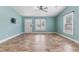 Bright living room with light blue walls, laminate floor, large window, and direct access to the front door at 600 Cuddington Ln, Nashville, NC 27856
