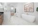 Modern bathroom with a soaking tub, glass-enclosed shower, marble tile, and stylish fixtures at 604 Edmund St, Raleigh, NC 27604