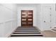 Inviting entryway featuring paneled walls, a striped rug, and a solid wood door with glass inserts at 604 Edmund St, Raleigh, NC 27604