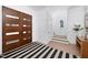 Bright foyer features a wood door and a black and white striped rug on wood floors at 604 Edmund St, Raleigh, NC 27604