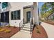 Modern home entrance featuring sleek door, black-framed windows, stone steps, and landscaped yard at 604 Edmund St, Raleigh, NC 27604