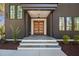 Inviting front entrance with stone steps, wood doors, and modern lighting fixture creates a warm welcome at 604 Edmund St, Raleigh, NC 27604