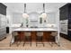 Modern kitchen features a marble island, pendant lights and seating for four at the breakfast bar at 604 Edmund St, Raleigh, NC 27604