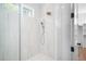 Modern shower with dual showerheads, white marble tile, and glass enclosure, adjacent to closet at 604 Edmund St, Raleigh, NC 27604