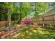 Idyllic backyard featuring lush greenery, a charming garden table, and a beautiful flowering bush at 605 Wyndham Dr, Fuquay Varina, NC 27526