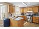 A well-lit kitchen with wooden cabinets, granite countertops and stainless steel appliances at 605 Wyndham Dr, Fuquay Varina, NC 27526