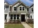 Charming two-story townhome with stone accents, manicured lawn, and welcoming entrance at 6405 Granite Quarry Dr, Raleigh, NC 27610