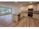 Bright kitchen with stainless appliances, granite countertops, island, and adjacent living area at 6405 Granite Quarry Dr, Raleigh, NC 27610