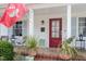 Inviting front porch with seating, decorative plants and a red front door creating a warm and welcoming entry at 711 S East Street St, Raleigh, NC 27601