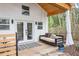 Relaxing guesthouse porch features a swing bed, outdoor seating, and a cozy atmosphere with wooded views at 711 S East Street St, Raleigh, NC 27601
