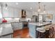 An open kitchen features white cabinets, stainless steel appliances, and a stylish island with seating at 711 S East Street St, Raleigh, NC 27601