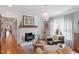 Cozy living room with hardwood floors, a fireplace, and comfortable seating beneath a stylish chandelier at 711 S East Street St, Raleigh, NC 27601
