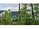 View of a two-story home framed by lush greenery, showcasing its serene natural surroundings at 724 Red Arrow Dr, Knightdale, NC 27545