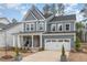 Stylish two-story home with gray siding, stone accents, a welcoming porch, and a convenient two-car garage at 724 Red Arrow Dr, Knightdale, NC 27545