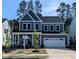 Beautiful two-story home featuring blue siding, stone accents, a welcoming front porch, and a two-car garage at 724 Red Arrow Dr, Knightdale, NC 27545