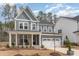 Charming two-story home boasts stylish gray siding, stone accents, a cozy porch with chairs, and a two-car garage at 724 Red Arrow Dr, Knightdale, NC 27545