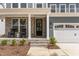 Inviting front porch with stone pillars, seating, and a stylish front door of a two-story house at 724 Red Arrow Dr, Knightdale, NC 27545