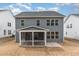 Rear view of a two-story home featuring gray siding, ample windows, and a cozy screened-in porch at 724 Red Arrow Dr, Knightdale, NC 27545