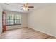 Neutral bedroom with hardwood flooring, ceiling fan, and natural light at 7820 Falcon Rest Cir, Raleigh, NC 27615