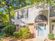 Charming townhouse featuring a blue front door with a black awning, complemented by lush greenery and mature trees at 7820 Falcon Rest Cir, Raleigh, NC 27615