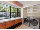 Well-lit laundry room with front loading washer and dryer and storage cabinets at 7820 Falcon Rest Cir, Raleigh, NC 27615
