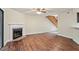 Open-concept living space features hardwood floors, a fireplace, and seamless transition to the adjoining staircase at 7820 Falcon Rest Cir, Raleigh, NC 27615