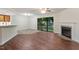 Bright living room featuring hardwood floors, a fireplace, and a sliding glass door leading to the outdoor space at 7820 Falcon Rest Cir, Raleigh, NC 27615