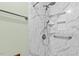 Modern shower with marble-look surround, shelving, and a handheld shower head at 7820 Falcon Rest Cir, Raleigh, NC 27615