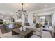 Open concept living room flows into the kitchen and dining areas, featuring a modern chandelier and stylish decor at 800 Emerald Bay Cir, Raleigh, NC 27610