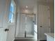 Bathroom with a glass shower enclosure, white tile, and natural light from a window at 804 Hillfarm Dr, Wake Forest, NC 27587