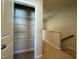 Walk in closet with wire shelving leading into hallway and carpeted staircase at 804 Hillfarm Dr, Wake Forest, NC 27587