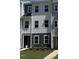 Charming townhome showcasing a modern facade with a combination of white and blue siding and freshly landscaped lawn at 804 Hillfarm Dr, Wake Forest, NC 27587