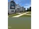 New townhomes feature modern gray and white exteriors and walkways across landscaped lawns under a clear blue sky at 804 Hillfarm Dr, Wake Forest, NC 27587