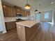 Spacious kitchen featuring wood cabinets, stainless appliances, island with white countertop and pendant lighting at 804 Hillfarm Dr, Wake Forest, NC 27587